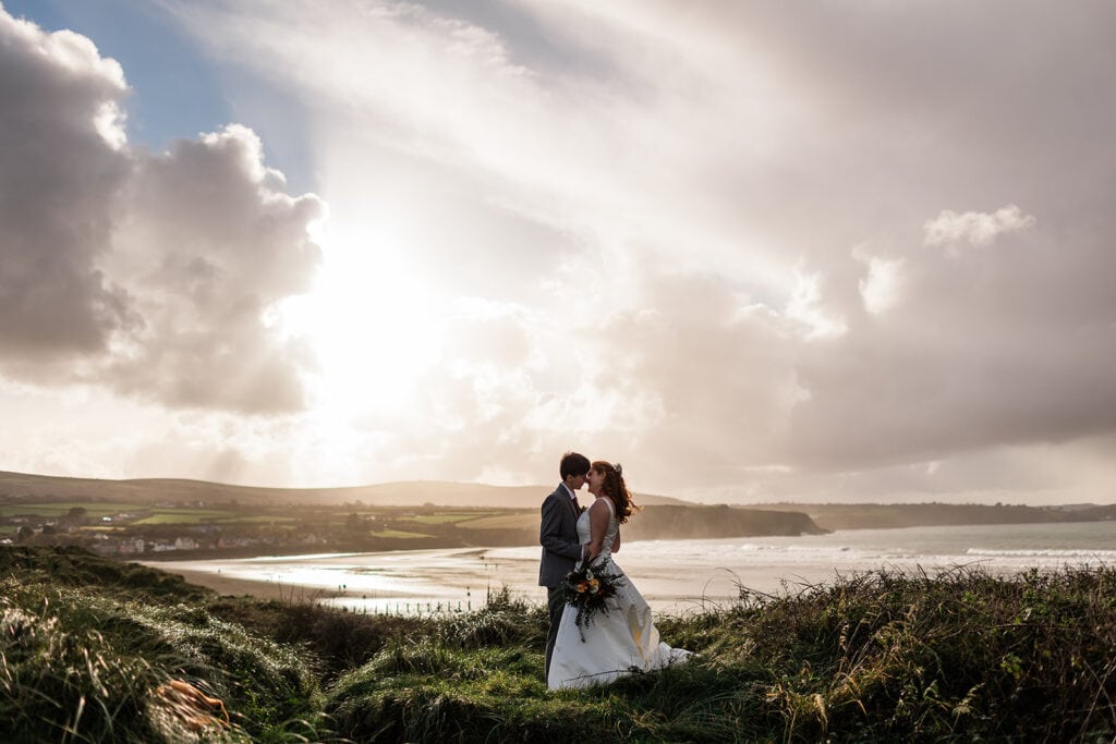 couple kiss with dramatic skies on beach in newport pembs